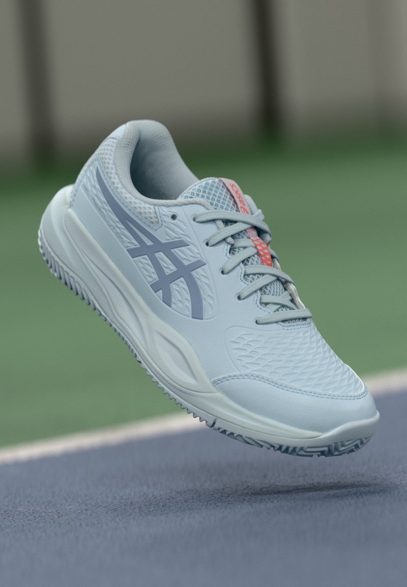 Světle modrá sportovní bota s prodyšnými akcenty, texturovaným povrchem a vzorovanou podrážkou. Obsahuje šedé logo a růžový akcent na jazyku.