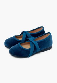 Ballerine in velluto blu con punta rotonda, caratterizzate da un evidente nastro di chiusura e una superficie testurizzata, poggiate su una suola piatta nera.