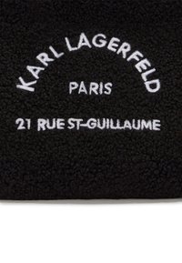 Tissu en polaire noir affichant "KARL LAGERFELD", "PARIS" et "21 RUE ST-GUILLAUME" en broderie blanche, avec une surface texturée.