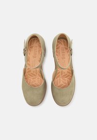 Scarpe Mary Jane verde in suede con punta tonda, cinturino alla caviglia e soletta imbottita con motivo a foglia.