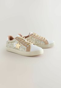 Baltas sporta apavi ar zelta spīduma akcentiem, gaiši brūnas zamšādas sānu paneļi un zvaigžņu dizains, zelta šņorēm, ar gumijas zoli.