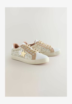 Baltas sporta apavi ar zelta spīduma akcentiem, gaiši brūnas zamšādas sānu paneļi un zvaigžņu dizains, zelta šņorēm, ar gumijas zoli.