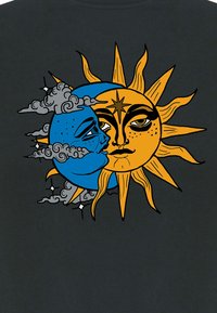Maglietta nera con un design di sole e luna. Sole arancione con raggi, luna blu, contornata di nero, con nuvole grigie e accenti di stelle.