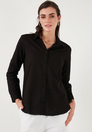Black button-up shirt made of lightweight fabric with long sleeves, collar, single chest pocket, and a curved hemline.