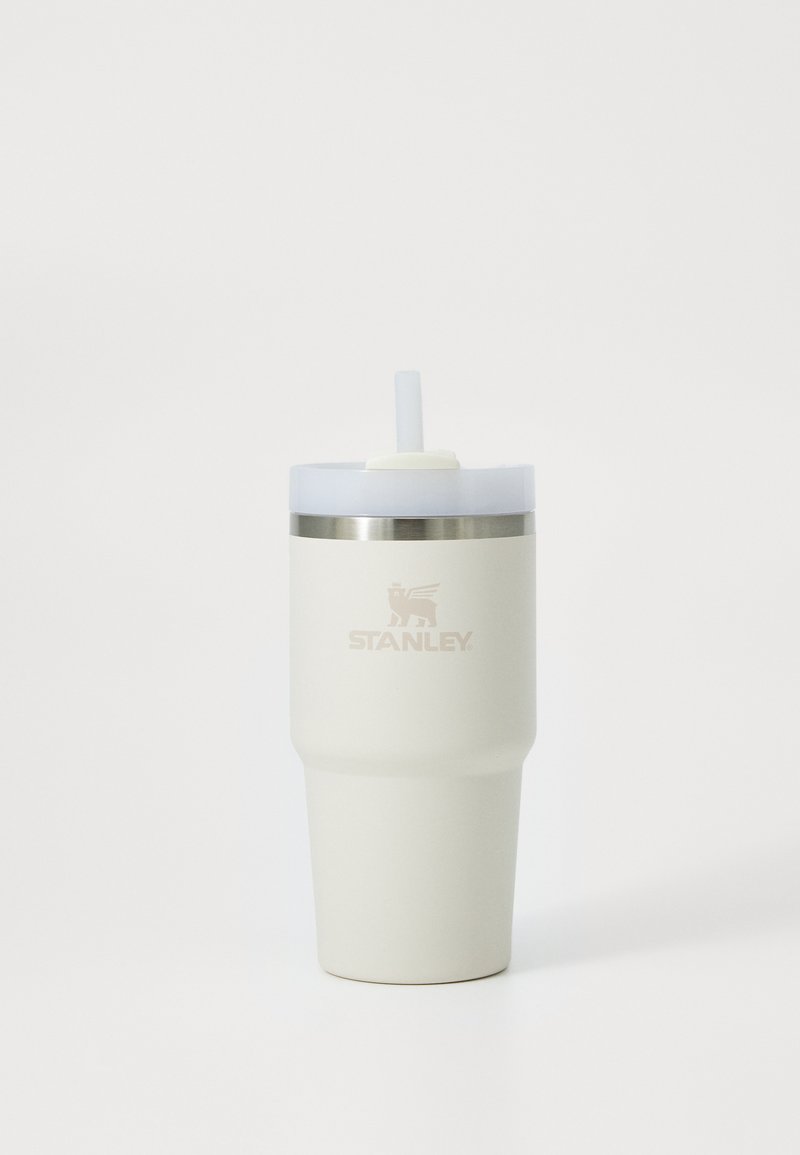 Weißer Stanley Isolier-Reisebecher mit klarem Deckel und integriertem Strohhalm vor weißem Hintergrund.
