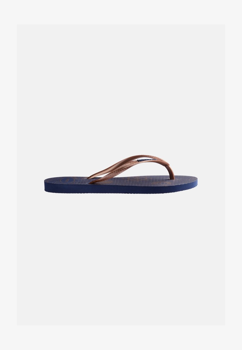 Σαγιονάρα ναυτικού μπλε με υφή στη σόλα και καφέ λουράκι σε σχήμα Υ σε απλό ανοιχτό φόντο.