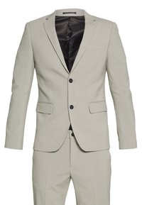Completo grigio chiaro realizzato in tessuto liscio. Presenta un giacca monopetto con due tasche frontali e chiusura con bottone nero. Fodera interna texturizzata.