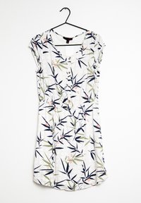 Šaty s krátkými rukávy vyrobené z lehkého materiálu, s květinovým vzorem zahrnujícím zelené listy a malé růžové květy na bílém pozadí.