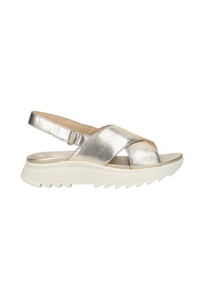 Sandale en cuir métallisé argenté avec lanières croisées, bride arrière ajustable, semelle intérieure rembourrée et semelle extérieure épaisse blanche texturée.