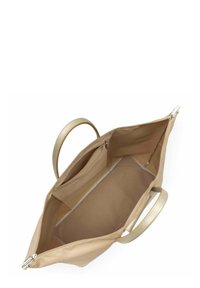 Sac fourre-tout beige avec finition brillante. Comprend un tissu intérieur lisse, des doubles poignées et une poche zippée. Aucun motif ou accent visible.