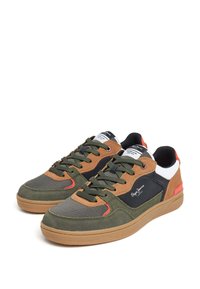 Zapatillas multicolores con parte superior de textil en verde oliva, marrón y negro, con suela de goma y colores de acento en rojo y blanco.