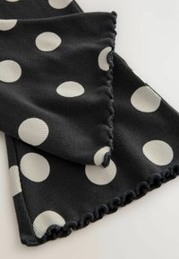 Sciarpa a pois nera e crema. Tessuto a costine con bordi scallopati. Presenta grandi cerchi bianchi su uno sfondo scuro.