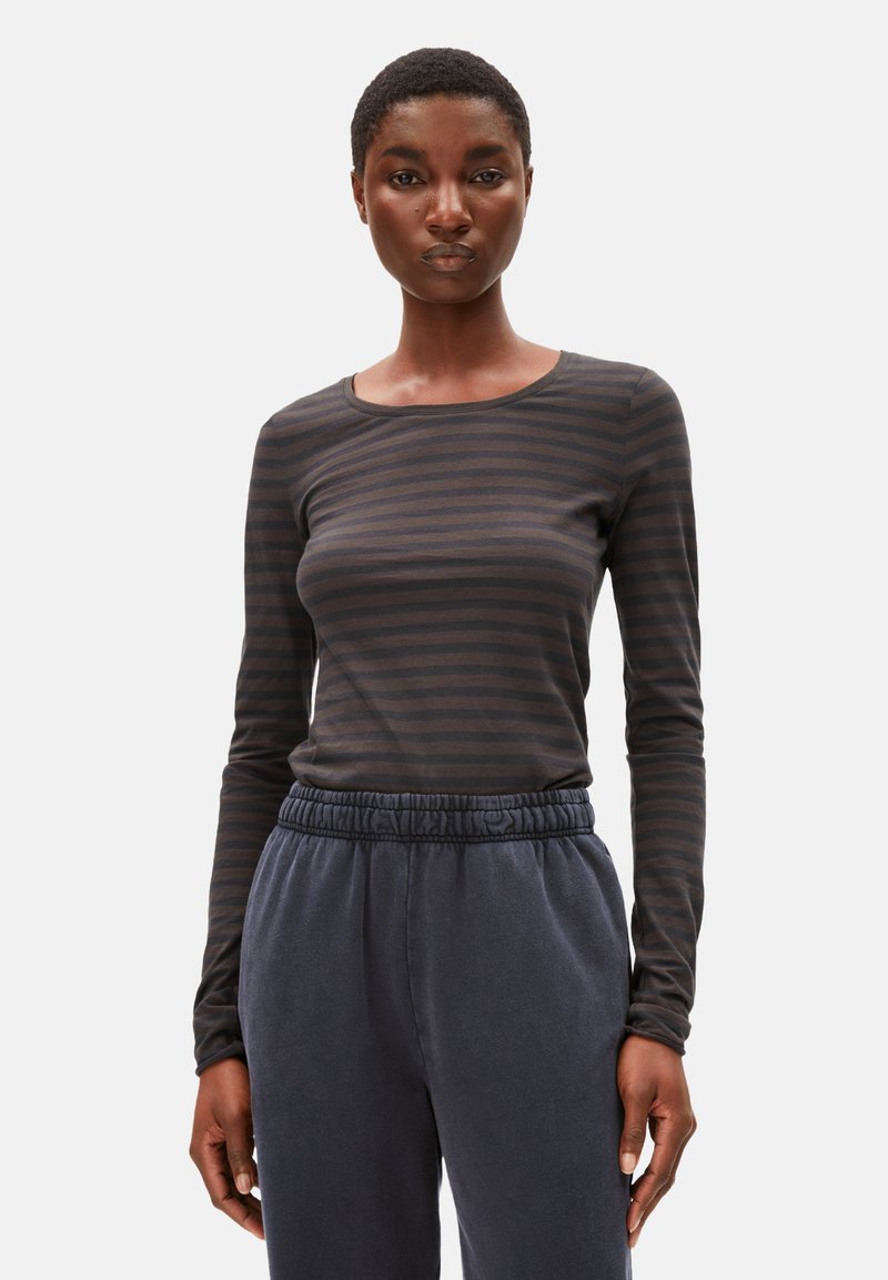 Langärmliges, dunkelgraues gestreiftes Shirt aus weichem Material mit Rundhalsausschnitt. Dazu weite marineblaue Jogginghosen mit elastischem Bund.