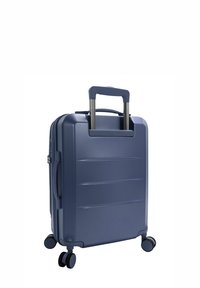 Valigia rigida blu navy con manico telescopico, texture a righe e quattro ruote multidirezionali per una facile mobilità.