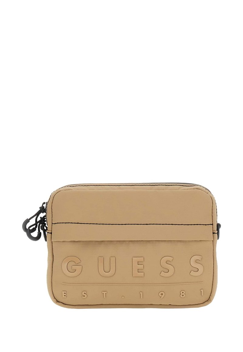 Pungă din nylon bej cu logo-ul embosat "GUESS EST. 1981", formă rectangulară, închidere cu fermoar superior, accesorii negre și suprafață texturată.