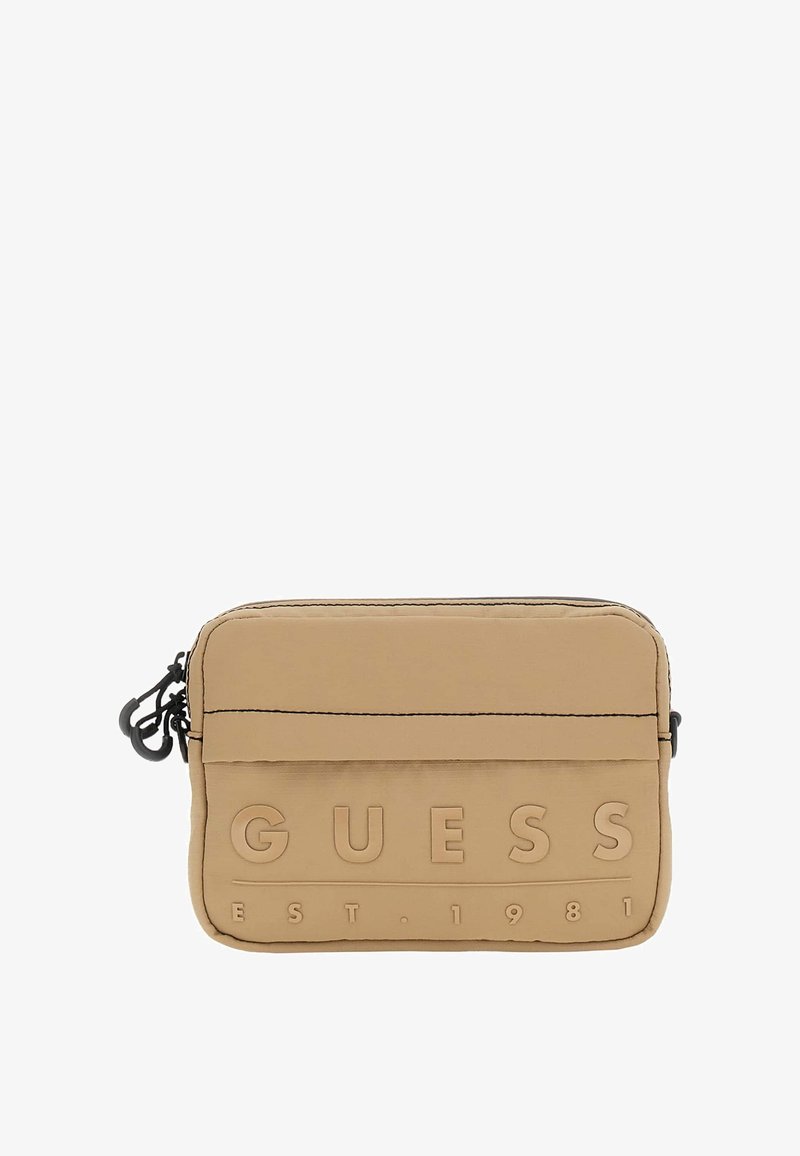 Pungă din nylon bej cu logo-ul embosat "GUESS EST. 1981", formă rectangulară, închidere cu fermoar superior, accesorii negre și suprafață texturată.
