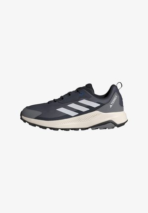 Dark gray and black Adidas Terrex trail running shoe with white stripes and rugged sole, side view on a white background.
