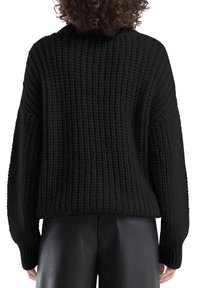 Zwarte gebreide trui met een gestructureerde afwerking, voorzien van een losse pasvorm, doorgezakte schouders en lange mouwen. Simpele, geribde manchetten en zoom.