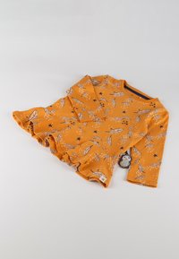 Long-sleeve dress in mustard yellow fabric with leaf and star patterns, featuring a ruffled hem and a small pendant detail.