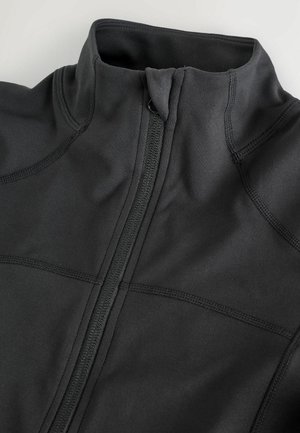 Černá sportovní bunda s vysokým límcem, předním zipem, zesílenými švy a hladkým, elastickým materiálem. Minimalistický design bez vzorů.