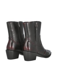 Botas de cuero negro hasta el tobillo con costuras rojas, cremalleras laterales y un tacón cuadrado. Presentan un acabado suave y un diseño decorativo en la puntera.