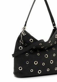 Mustast kangast õlakott, millel on erineva suurusega hõbedased metallist silmad ja hõbedast kirjadega ripatsid rihmal.