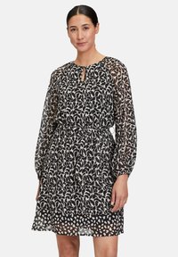 Schwarz-weißer Kleid mit Muster, Keyhole-Ausschnitt, transparenten langen Ärmeln und elastischem Taillenbund. Mehrlagiger, leichter Stoff.