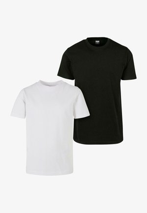 Czarny t-shirt z krótkim rękawem o luźnym kroju, w połączeniu z jasnobeżowymi spodniami cargo z bocznymi kieszeniami oraz czarno-białymi sneakersami.