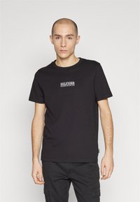 T-shirt in cotone nero con un logo "HILFIGER" centrale bianco e blu. Collo a giro classico e maniche corte; vestibilità comoda.
