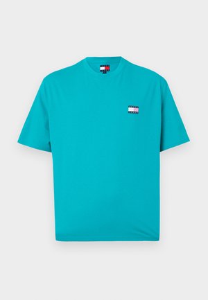 Tricou din bumbac turcoaz, cu gât rotund, mâneci scurte și un mic patch cu logo pe piept, având dungi roșii, albe și albastre.