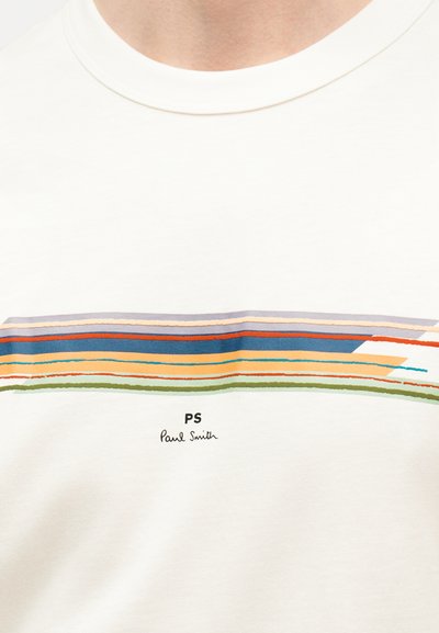Λευκό μπλουζάκι με στρογγυλή λαιμόκοψη και οριζόντιες πολύχρωμες ρίγες, με το κείμενο «PS Paul Smith» κεντραρισμένο κάτω από τις ρίγες.