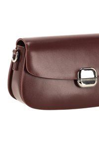 Geantă de mână din piele vișinie, cu finisaj neted, închidere cu clapetă și o încuietoare dreptunghiulară argintie. Dispune de o buclă laterală pentru atașarea unei curele.
