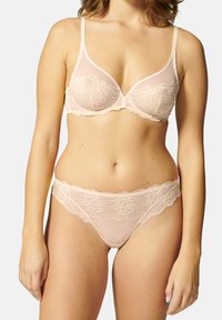Bralette en dentelle et string assorti en nude clair. Le bralette présente des bonnets moulés et des bretelles réglables ; le string a un bord festonné et un motif en dentelle florale.