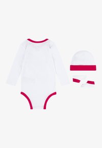 Λευκό κορμάκι μακρύ μανίκι με ροζ λεπτομέρειες, συνοδευόμενο από ένα καπελάκι και καλτσάκια με ροζ λεπτομέρειες. Υφασμα από βαμβάκι, μαλακή υφή.