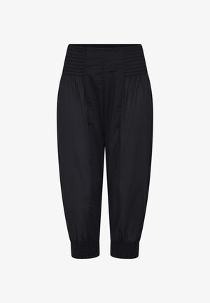 Crne hlače širokog kroja s širokim nabranim pojasom i nabrane manšete na gležnjevima, izrađene od laganog tkanja.