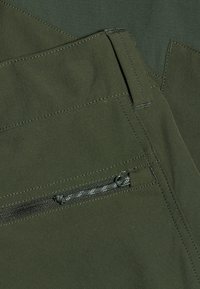 Olijfgroen stof met een gladde textuur, met gestikte naden en een zak met rits. Eenvoudig, functioneel ontwerp zonder patronen.