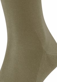 Calzino verde oliva, materiale in misto cotone, trama finemente rigata, forma sagomata, punta senza cuciture e tallone rinforzato.