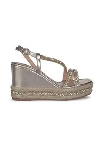 Sandali con zeppa e fasce in argento metallico, adornati con strass. Presentano una base intrecciata testurizzata e una finitura lucida. Chiusura a fibbia.
