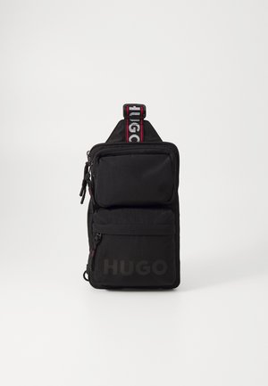 Sac bandoulière noir Hugo avec deux compartiments zippés et sangle avec logo sur fond blanc.