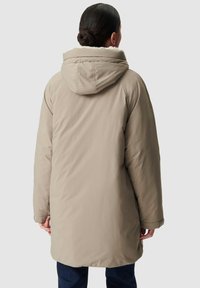 Parka beige con cappuccio, dotata di un interno morbido e texture; vestibilità ampia e design di lunghezza media. Presenta cuciture piatte e una chiusura con zip.