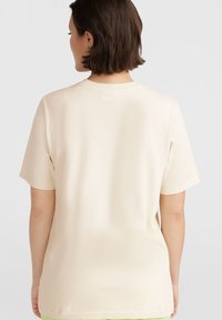 Camiseta de manga corta color crema con un corte relajado. Textura suave y diseño sencillo, con un cuello redondo clásico y sin adornos.