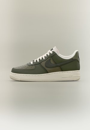 Παπούτσι τύπου sneaker χαμηλού ύψους σε ελαιί πράσινο με λευκά κορδόνια και σόλα, λογότυπο Nike στο πλάι και οπές στην περιοχή των δαχτύλων.