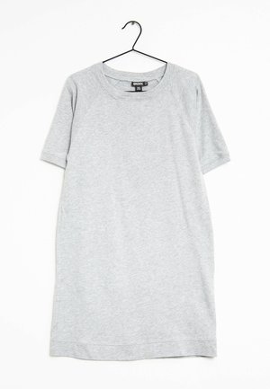 Robe décontractée à manches courtes gris clair suspendue sur un cintre en fil noir contre un fond blanc.
