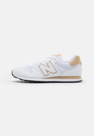 Weißer und beiger Sportschuh mit Mesh- und Lederobermaterial, Schnürverschluss und Gummisohle auf weißem Hintergrund.