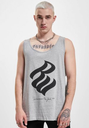 Grå tank topp med et stort svart abstrakt logo og teksten "ETABLERT New York 1991." Laget av bomull med en avslappet passform og brede stropper.