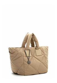 Beige quilted tote bag with double fabric handles, chain accent, and square tags on each side. Soft texture and puffy shape.