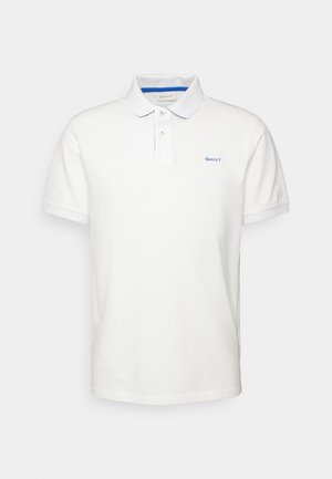 Bílá polo košile z bavlny, s klasickým límcem, tříknoflíkovým zapínáním a modrým vyšitým logem na hrudi.