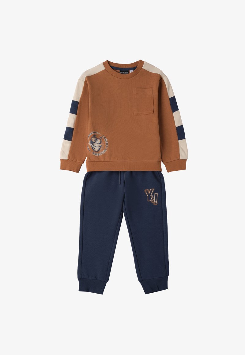 Felpa marrone con accenti beige e blu navy, dotata di una piccola tasca e della grafica "Energia Positiva". Pantaloni della tuta blu navy con dettaglio del logo.