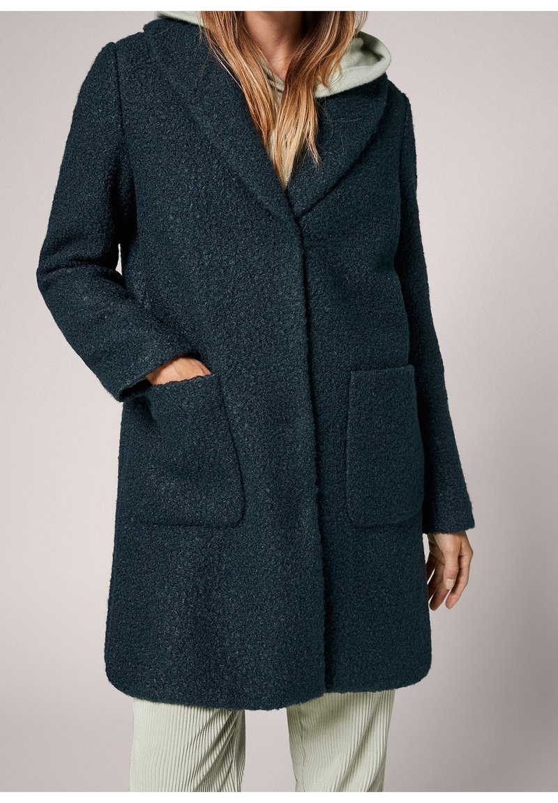 Tummanvihreä villasekoitetakki, jossa on teksturoitu pinta, suuri huivikaulus, kaksi etutaskua ja rento istuvuus.