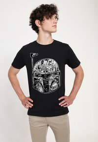 Camiseta negra con un gráfico detallado en blanco de un casco, que incorpora escenas y personajes, con mangas cortas y cuello redondo.